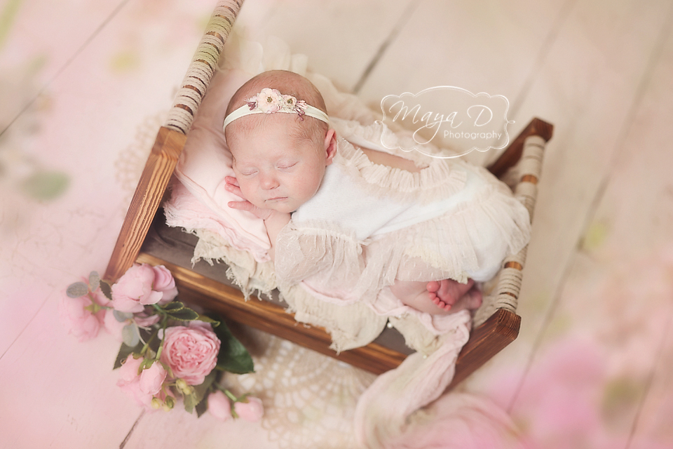 Newborn baby sleeping in bed surround by flowers, Columbus OH studio